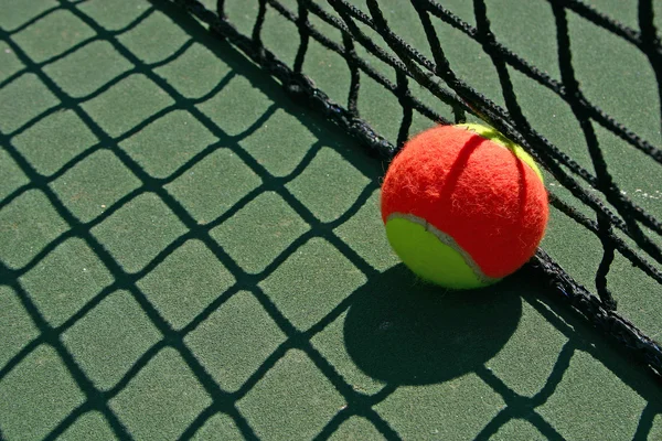 Tennis ball besides the net — Stock Photo, Image