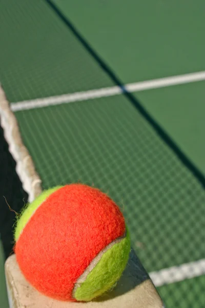 Теннисный мяч и теннисная сетка — стоковое фото