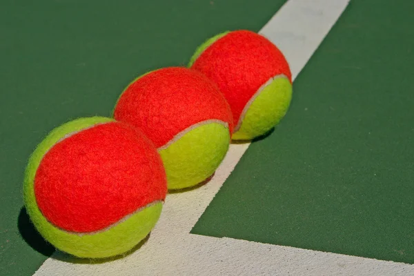 緑のコート上の 3 つのボール — ストック写真