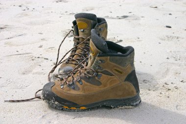 Hiking boots on the sand clipart