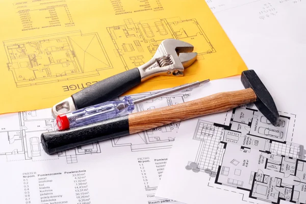 Herramientas en los planos de la casa incluyendo martillo, destornillador y llave inglesa —  Fotos de Stock