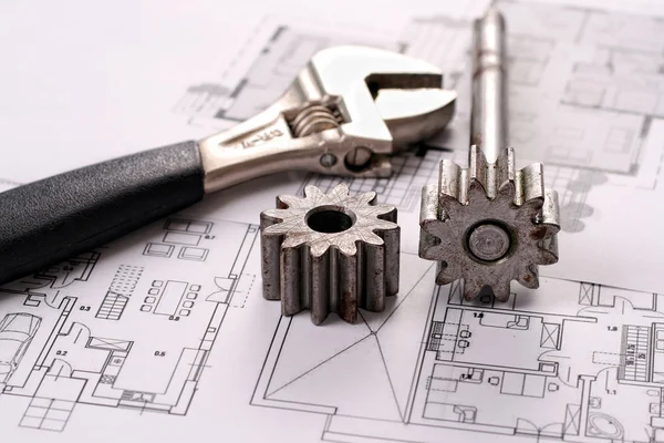 Werkzeuge auf Bauplänen, einschließlich getriebener Stapel und Affenschlüssel. — Stockfoto