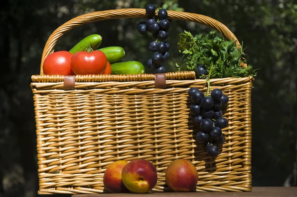 Picknickkorb mit Herbstfrüchten lizenzfreie Stockfotos