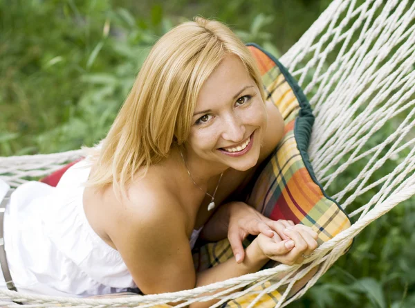 Giovane ragazza sorridente sdraiata su un'amaca — Foto Stock