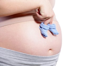 Pregnant woman's abdomen with a pair of baby socks clipart