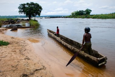 Men in a wooden boat on the river Congo clipart