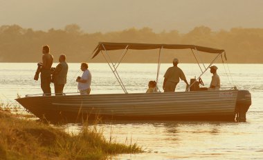 Photographers by a boat clipart