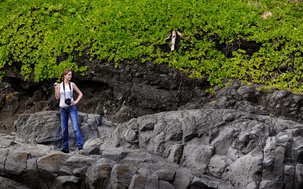 那个摄影师的女孩 有相机和支助费用在岩石上的女孩 — 图库照片