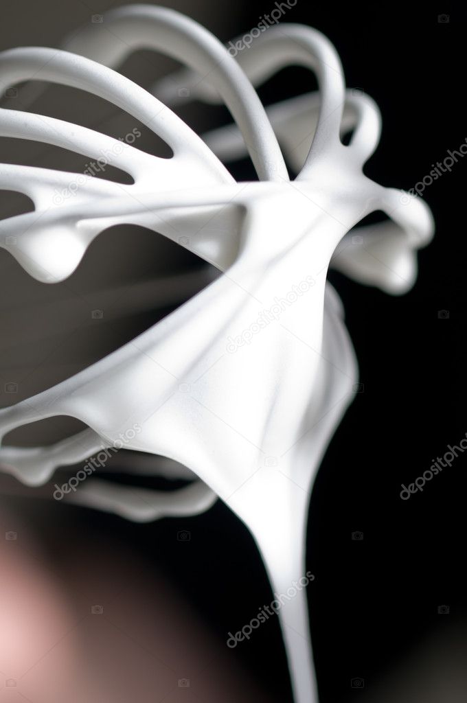 Whisk with creamy egg white close up