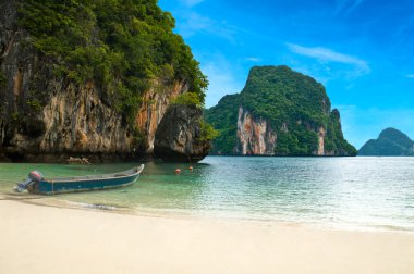 A long tail boat by the beach in Thailand clipart