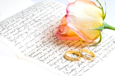 Red yellow rose, gold ring over a hand written love letter clipart