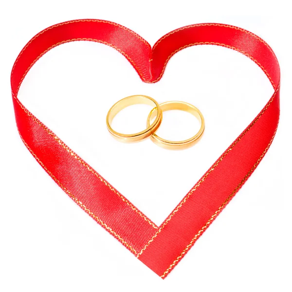 Χρυσά δαχτυλίδια στην πλευρά την καρδιά σχήμα κορδέλα在心脏一侧的金黄圆环形状功能区 — 图库照片