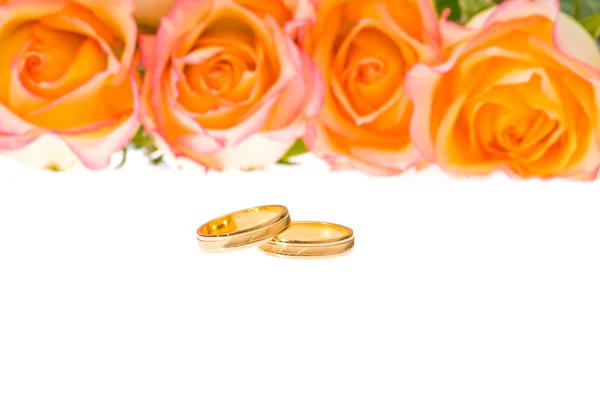 红黄色玫瑰和白上的金色结婚戒指 — 图库照片