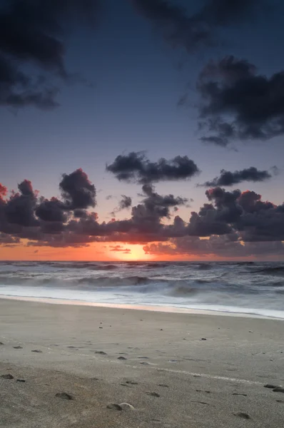 Une plage au coucher du soleil avec un ciel radieux — Photo