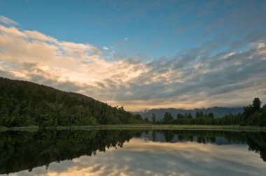 Sunrise above a lake on a wind still morning clipart