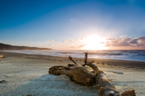 Pôr do sol sobre uma praia enevoada — Fotografia de Stock