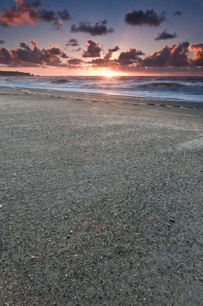 Ein Strand Bei Sonnenuntergang Mit Glühendem Himmel Mit Dunklen Wolken — Stockfoto