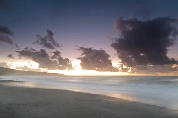 Een Strand Tijdens Mistige Zonsondergang Met Gloeiende Sky Donkere Wolken — Stockfoto