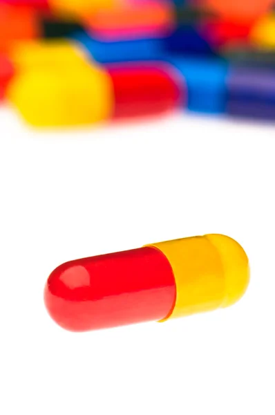 One red yellow capsule in front of many colorful — Stock Photo, Image