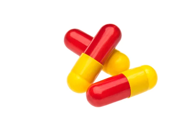 Three red yellow capsules over white — Stock Photo, Image