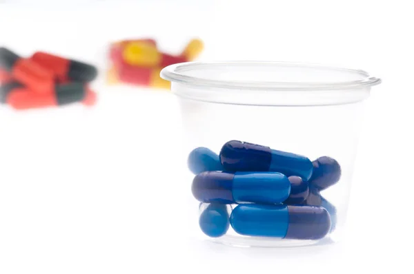 Comprimidos coloridos, cápsulas num copo — Fotografia de Stock