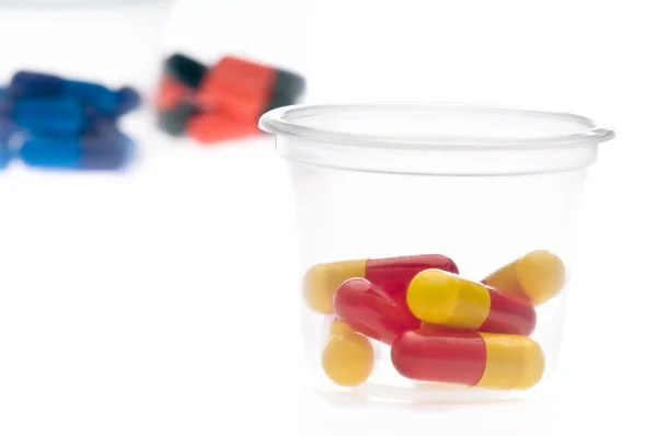 Comprimidos coloridos, cápsulas num copo — Fotografia de Stock