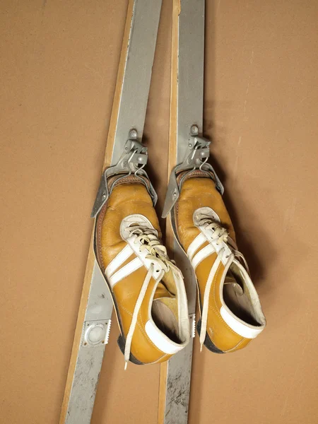 eski ski boots kahverengi renk ve kayaklar bir duvara yaslandı.