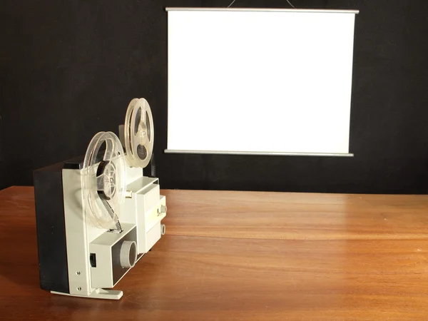 ログ壁に掛かっている画面を目指したフィルム映写機 — ストック写真