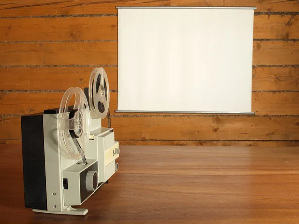 ログ壁に掛かっている画面を目指したフィルム映写機 — ストック写真