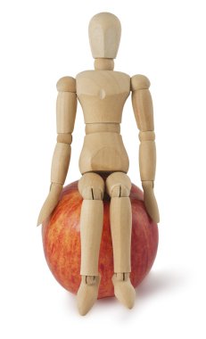 The wooden mannequin sits on a ripe apple clipart