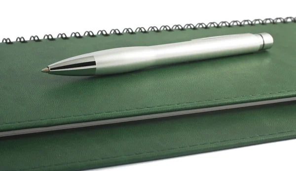 Ручка на зеленой спирали блокнота — стоковое фото
