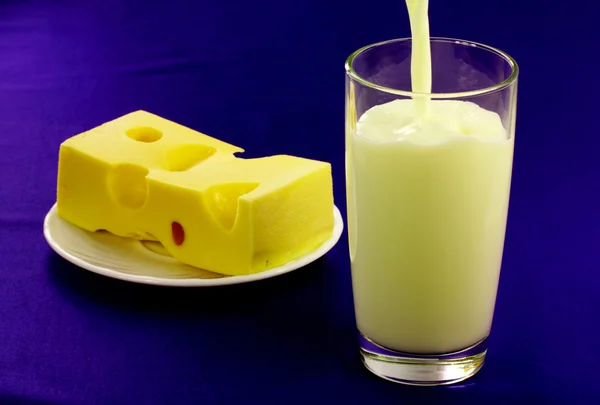 Um copo de leite e um pedaço de queijo — Fotografia de Stock