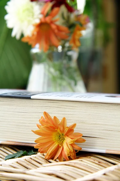 Książka na stole z kwiatami — Zdjęcie stockowe