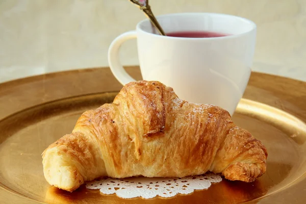 Croissant e uma xícara de chá — Fotografia de Stock
