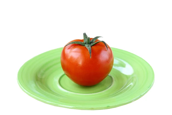 Tomate auf grünem Teller isoliert — Stockfoto