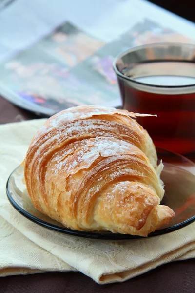 Croissant e uma xícara de chá — Fotografia de Stock