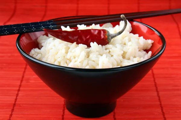 White rice in a black bowl with chopsticks — Stock Photo, Image
