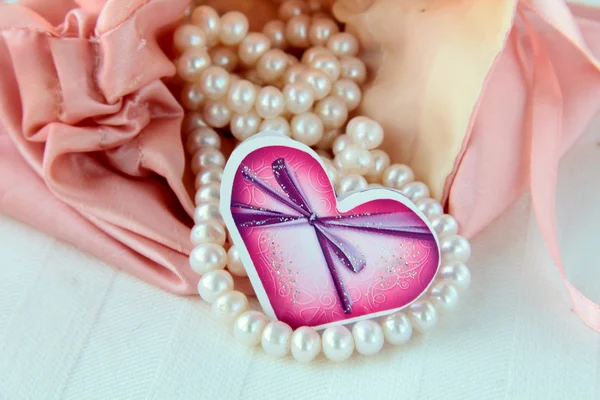 Witte parels in een roze zak — Stockfoto