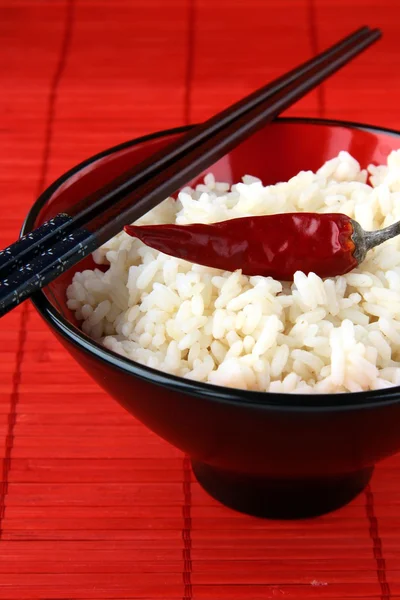 Белый рис в миске с черными палочками для еды — стоковое фото