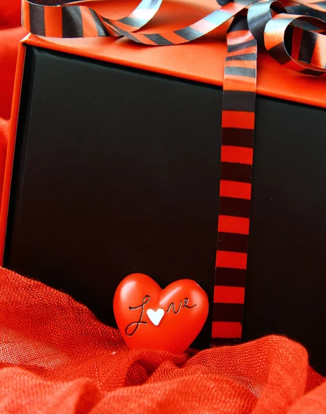 Röd ruta med en gåva och ett rött hjärta — Stockfoto