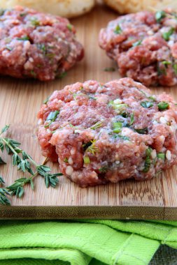 Raw minced meat for hamburgers on a wooden board clipart