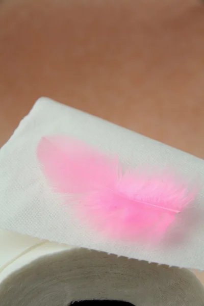 Rollo blanco de papel higiénico y una pluma rosa —  Fotos de Stock