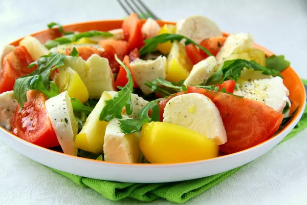 Salad with tomato and cheese arugula and olive oil — Stock Photo, Image