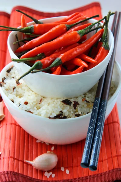 Skålar av okokt ris och chilipeppar — Stockfoto