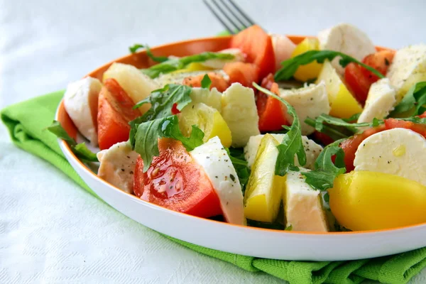 Salada com tomate e queijo rúcula e azeite — Fotografia de Stock