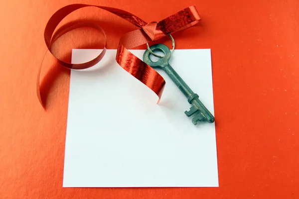 旧的密钥与一条丝带和红色背景上的卡 — 图库照片