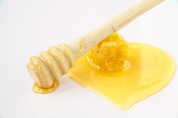 Honey dripping from a wooden honey dipper
