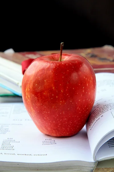 Red ripe apple with English textbooks — Stock Photo, Image