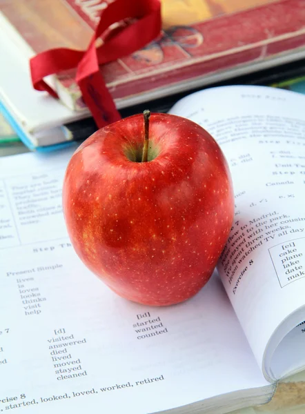 Κόκκινο ώριμο μήλο με τα Ελληνικά σχολικά βιβλία — Φωτογραφία Αρχείου