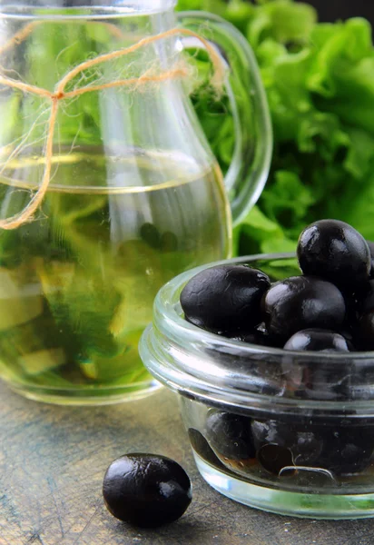 Aceitunas negras y una botella de aceite de oliva —  Fotos de Stock